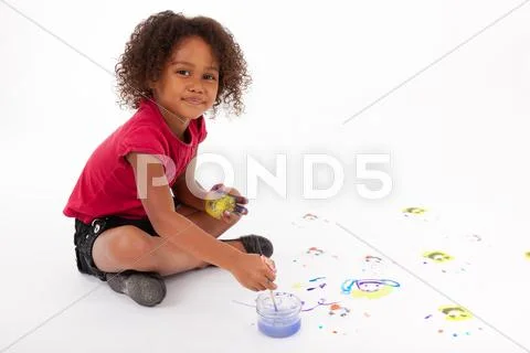 Little african asian girl painting on the floor Stock Photos