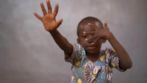 Little African Boy Posing With Stretched Fingers Stock Footage 122356418