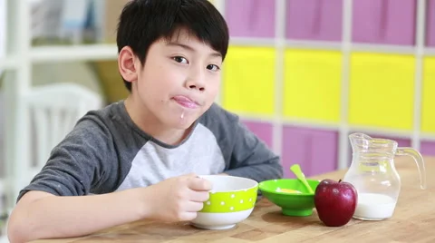 Little asian Boy eating cereal with milk... | Stock Video | Pond5