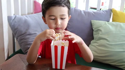 Little asian boy eats pop corn at a family cafe. Happy family time Stock Footage 159521931