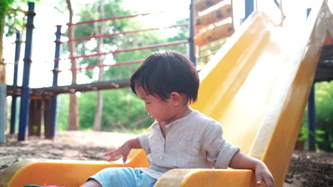 Little asian boy playing plastic slider kid at the playground city park Stock Footage 130893744