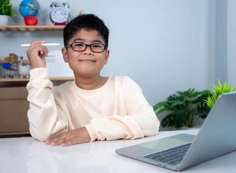 Little Asian boy student using computer laptop learning. Educational of tec.. Stock Photos