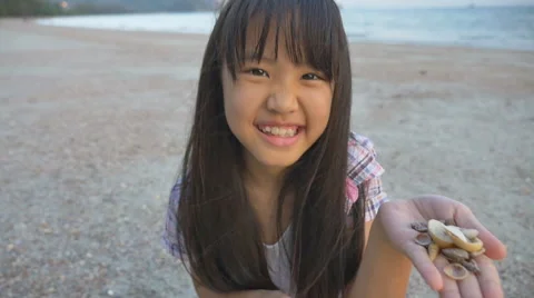 Little Asian child picking shells on the beach 스톡 동영상 49111931