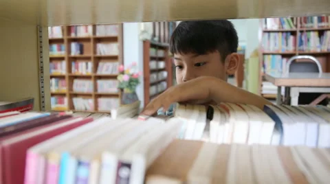 Little Asian child reading book in library Video stock 42771753