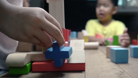 Little asian girl and boy playing wood blocks together Stock Footage