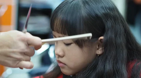 Little Asian girl getting haircut in hai... | Stock Video | Pond5