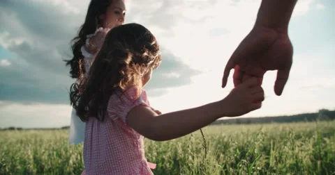 Little Asian girl walking on the green field with their parents, holding hands Stock Footage