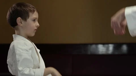 Little athlete performs blocks with his hands together with a trainer Stock Footage 272310148