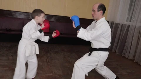 A little athlete in red pads performs punches on the trainer's palms Stock-Footage 317691837