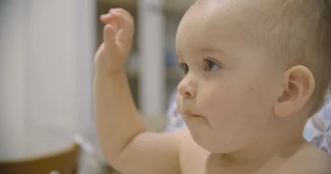 Little baby boy eats vegetable puree in the kitchen in the evening Stock Footage 113419214