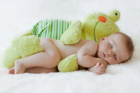 Little baby boy, sleeping with frog toy Stock Photos