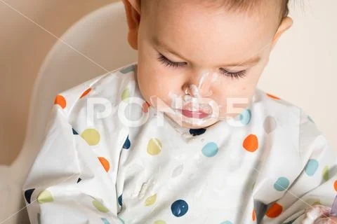 A Little baby eating her dinner and making a mess Stock Photos