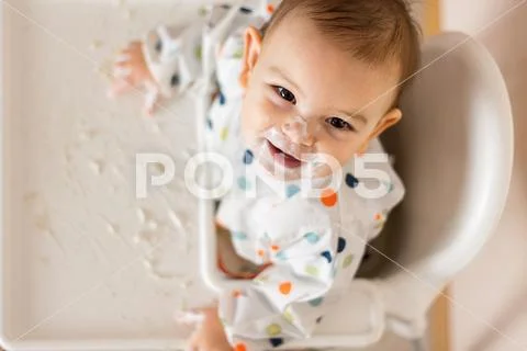 A Little baby eating her dinner and making a mess Stock Photos