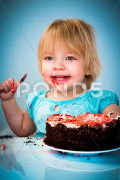 Little baby girl eating cake Stock Photos
