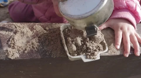 Little baby girl playing in a sandbox happy POV Stock Footage