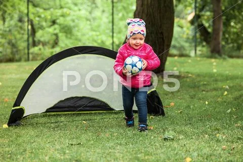 The little baby girl standing at park Stock Photos