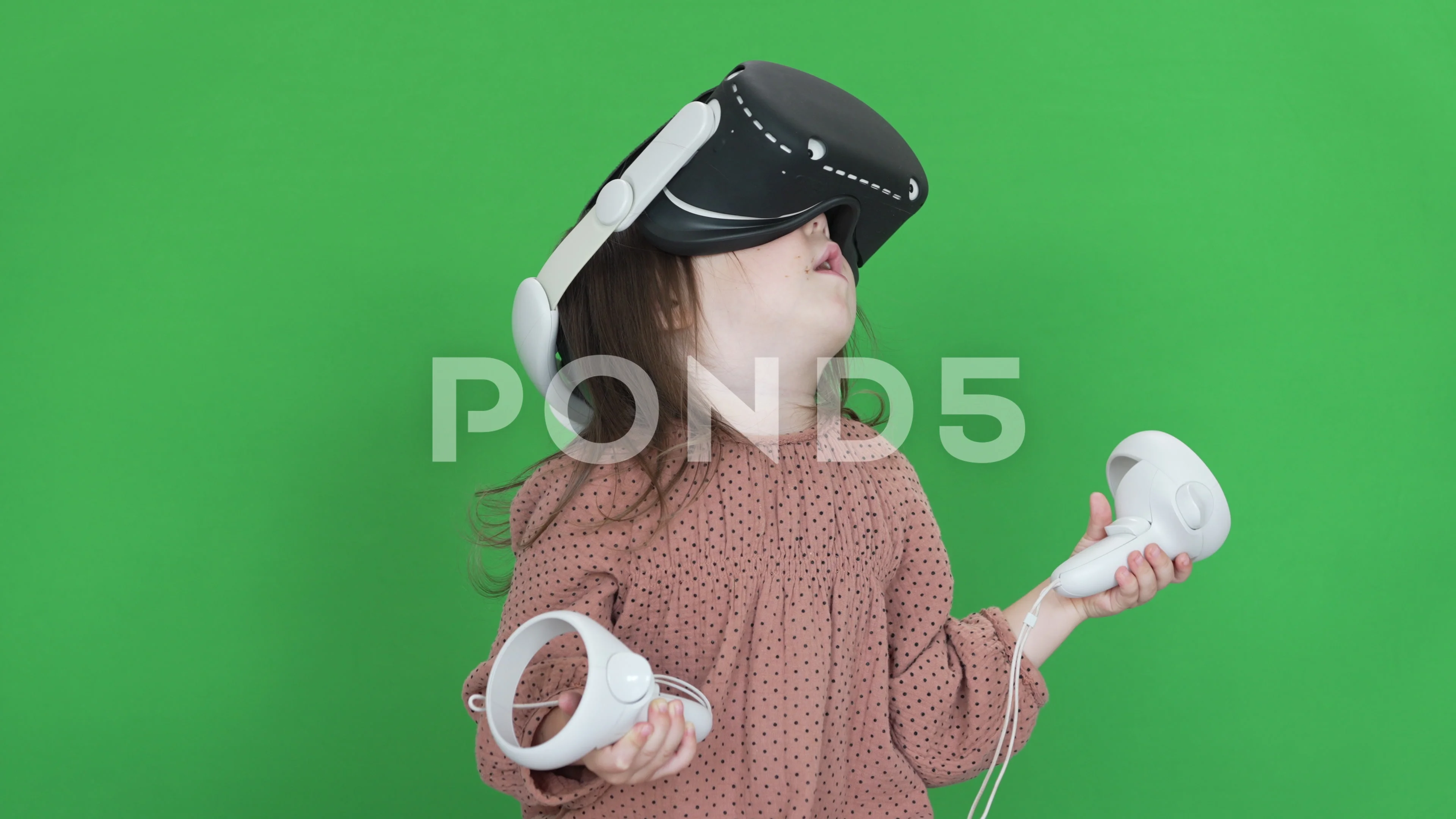 A Little Baby Girl is Using a Virtual Reality Helmet on Green Screen