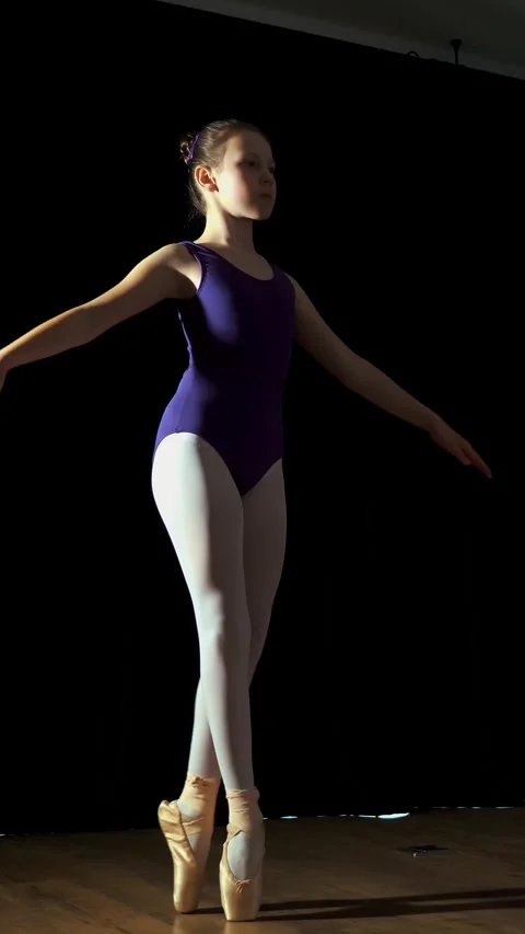 Little ballet dancer, girl in a purple ballet leotard, practicing pointe Stock Footage 313799692