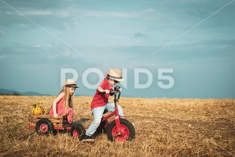 Little bikers with retro tricycle. Eco farm workers. Two little children on Stock Photos