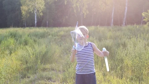 Little blond boy makes bubbles soap outside in a park Video stock 98283196