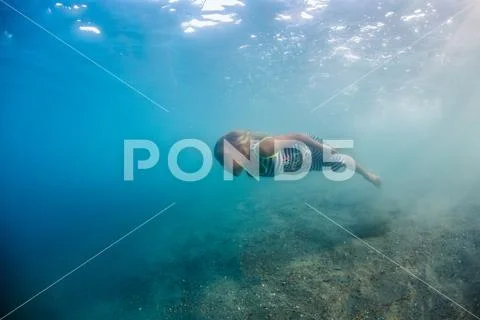 Little blonde girl in sea water underwater Stock Photos