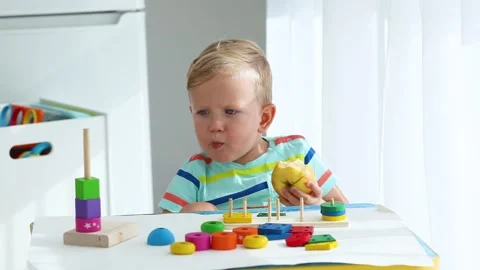 A little boy 2 years  eats an apple Stock Footage 142534089