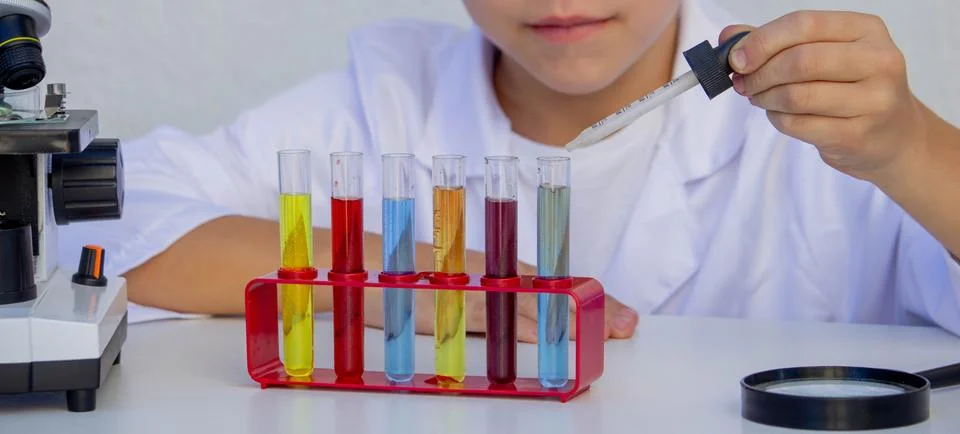 Little boy adding reagent into a test tube during a chemistry experiment Stock Photos
