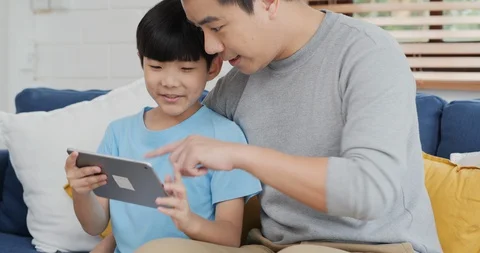 Little boy and father using tablet together with smile. 스톡 동영상 129891174