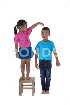 Little boy and girl measuring their height isolated on white background Stock Photos