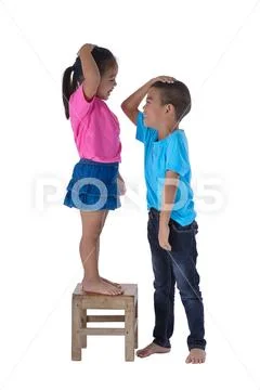 Little boy and girl measuring their height isolated on white background Stock Photos
