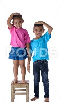 Little boy and girl measuring their height isolated on white background Stock Photos