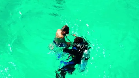 A little boy and an instructor scuba dive in the Red Sea over a coral reef. Stock Footage 324897490