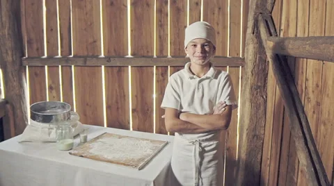Little boy in apron after making bread in the small wood house Stock Footage