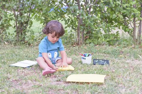 Little boy are using a magic pen to draw pictures in a book on a wooden table in Stock Photos