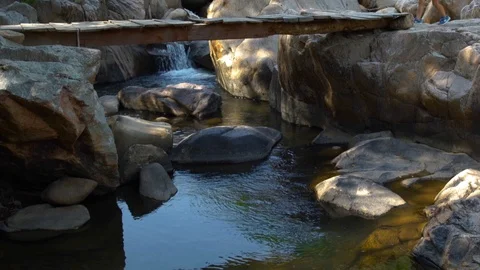 Little boy with backpack walking on dangerous bridge over rapid river while Stock Footage 90898678