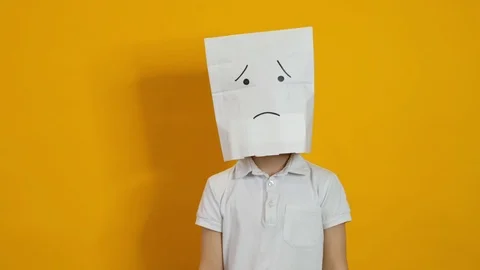 Little boy with a bag on his head - sad, dissapointed face on yellow background Vidéo 124278832