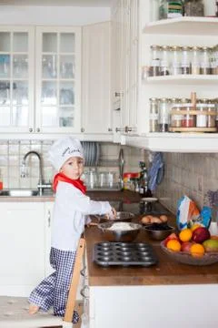Little boy, baking muffins in the kitchen Stock Photos