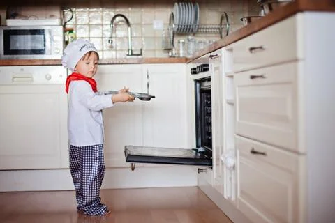 Little boy, baking muffins in the kitchen Stock Photos