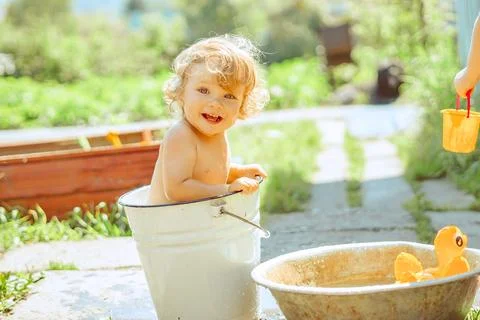 A little boy is bathing in a basin Stock Photos