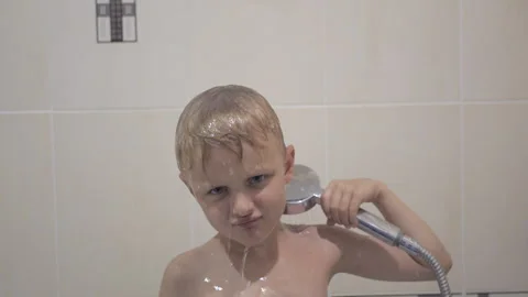 Little boy bathing under a shower at home and making funny faces Video stock 158159427