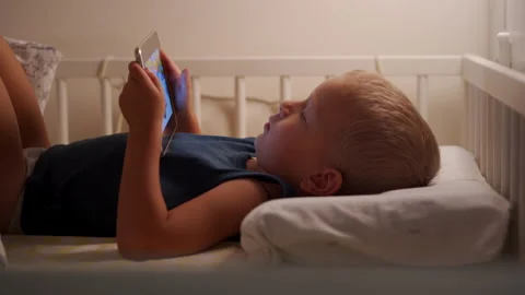 Little boy in bed mesmerized by tablet. Stock Footage 297535710