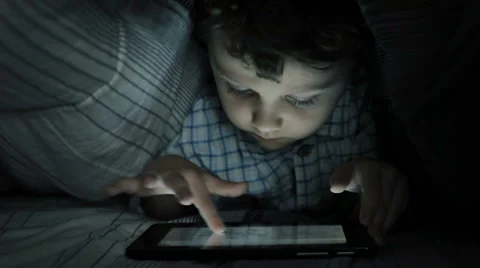 Little boy on the bed in the room using tablet Stock Footage 60575477