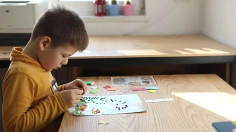 Little boy being creative making homemade do it yourself dinosaur mosaic. Stock Footage 168293447