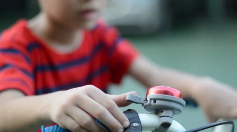 Little boy on Bicycle handlebars using bicycle bell Stockbeeldmateriaal 47750621
