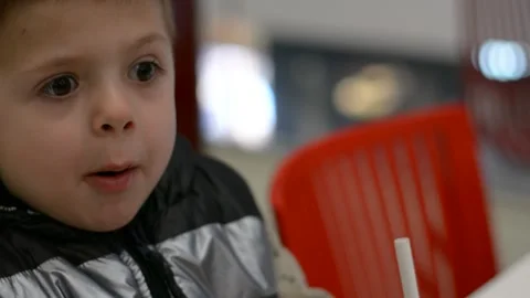 A little boy bites a hamburger. Fast food. A positive child, smiling. 스톡 동영상 170531489