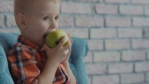 Little boy biting off apple Stock Footage 73707437