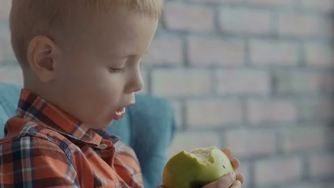 Little boy biting off apple Stock Footage 73711144