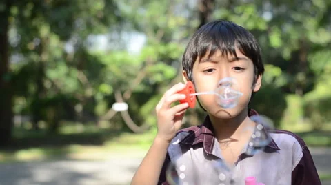 Little boy blowing bubble in the park Stockbeeldmateriaal 45634608