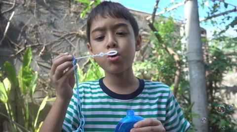 Little boy blowing bubble soap close up slow motion HD Stockbeeldmateriaal 65826091