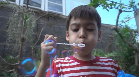 Little boy blowing bubble soap close up slow motion HD Stockbeeldmateriaal 65827416